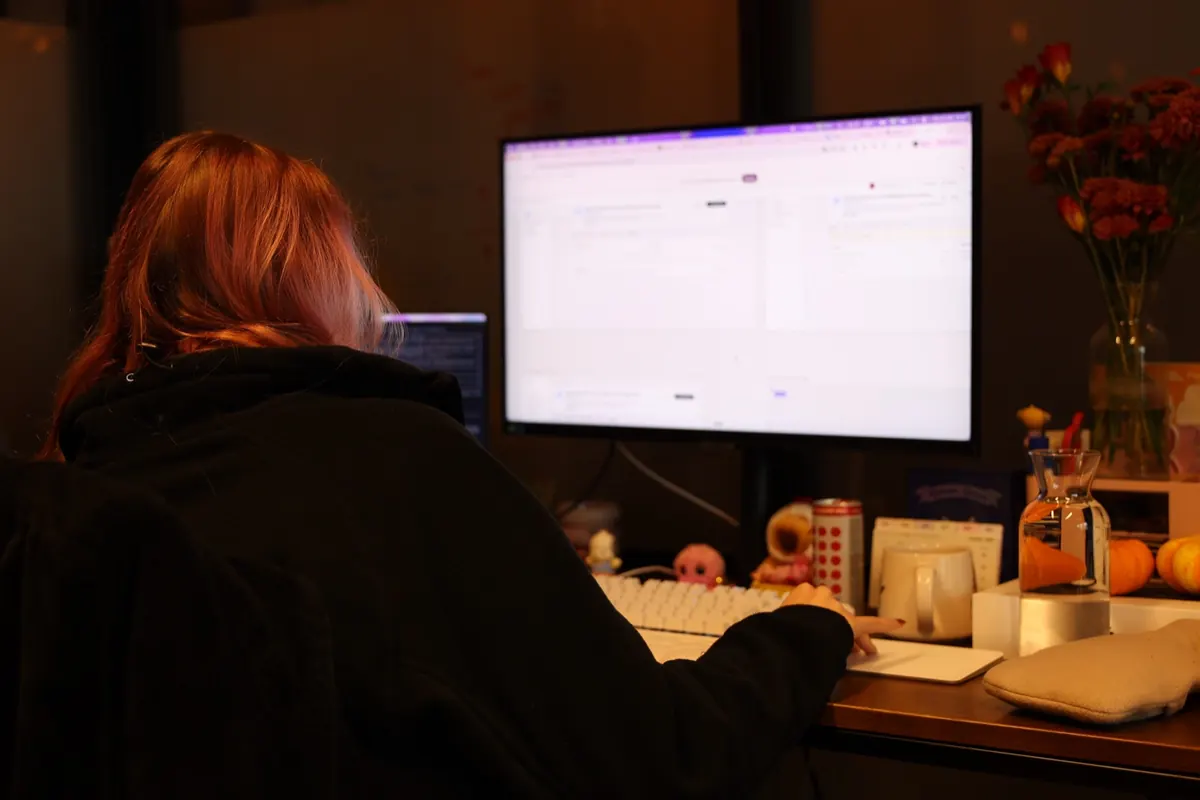 Our UX engineer working at a large monitor in a dim office in the evening