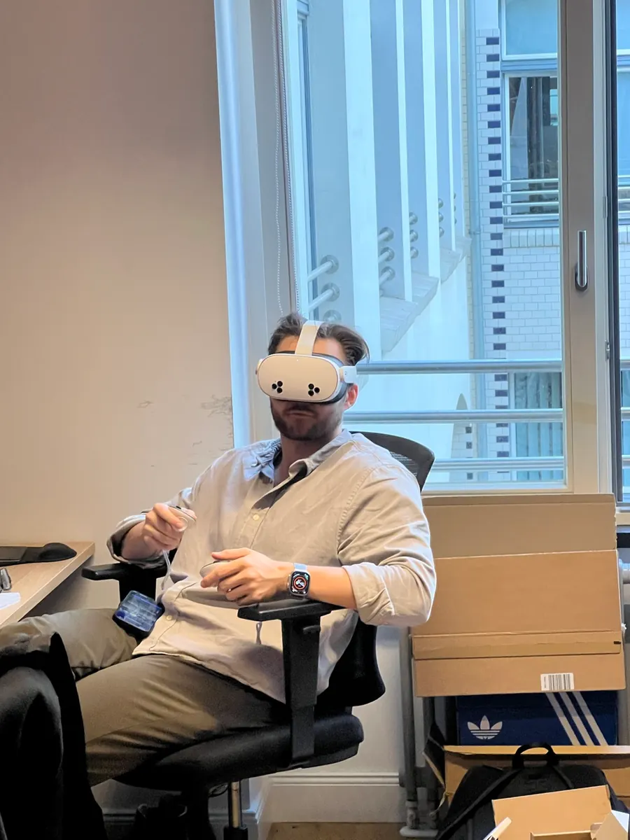One of our engineers in an office chair, wearing a white VR headset